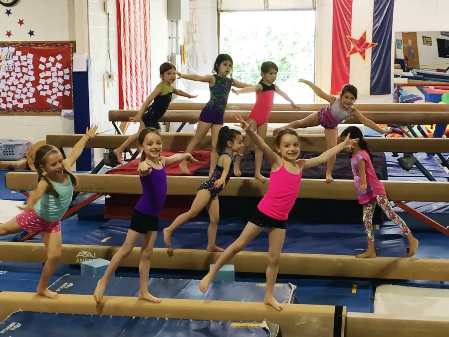A recreational class working across the balance beams